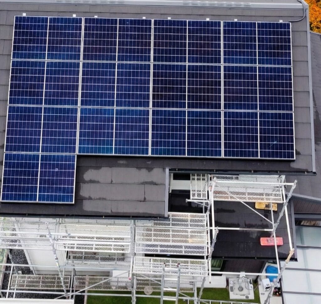 HanwhaハンファQセルズ太陽光パネル設置工事中の屋根 ドローン空撮写真（足場あり）